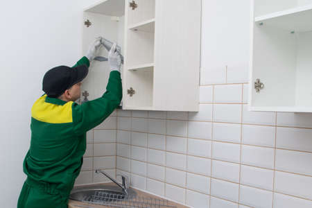 the master of installation, storage systems in the kitchen, inserts a grid for storing dishes in hanging cabinetsの写真素材