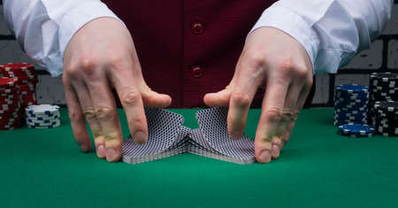 two hands on a green table stir two decks of cards, close-upの写真素材