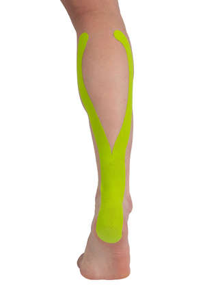 on a white background, close-up of a foot with a taped foot, for recovery from a sports injury, with a raised footの写真素材