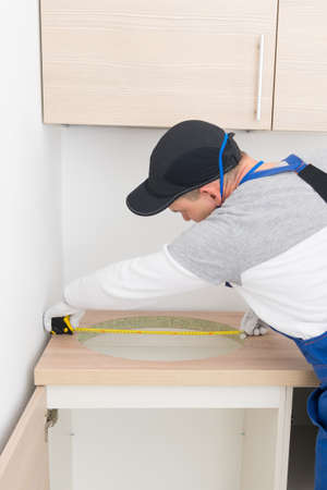 the master makes measurements of the hole before installing the sink, with a tape measureの写真素材