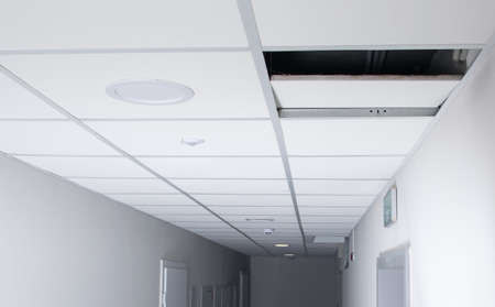 in the long corridor, the suspended ceiling plate is open, there is a place for the inscriptionの写真素材