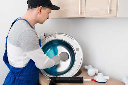 kitchen furniture assembler assembles the sink into the countertopの写真素材