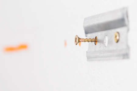 metal fasteners for kitchen furniture fixed on a concrete wall, close-upの写真素材