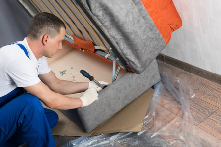 a man assembles a new sofa for the homeの写真素材