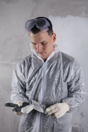 a worker applies mortar to a trowel to repair concrete wallsの写真素材