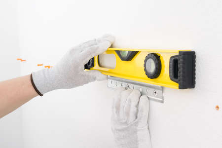 the yellow level checks whether the metal fittings for the suspended kitchen furniture have been installed evenlyの写真素材
