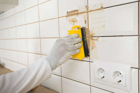 trowel for filling joints with grout after laying ceramic tiles on the wallの写真素材
