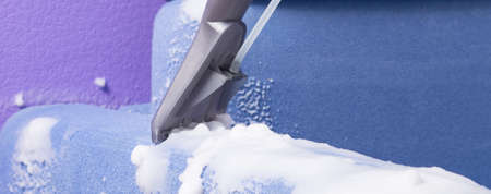vacuum cleaner with wet cleaning function, collects white foam from the blue fabric of the sofaの写真素材