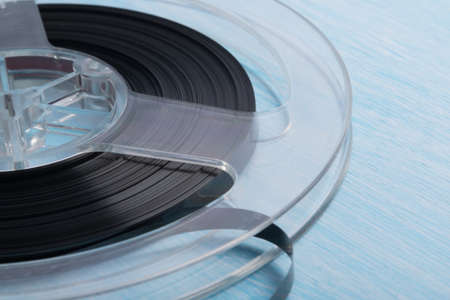 close-up of a reel with magnetic tape for recording music, retro version, on a blue backgroundの写真素材