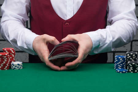 two hands on a green table, stirring on the weight, decks of cards, close-upの写真素材