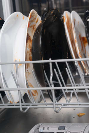 dirty dishes in the dishwasher net, close-upの写真素材