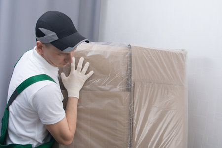 close-up of a delivery courier moving a large box by handの写真素材