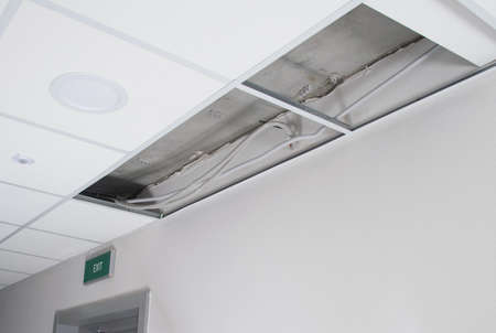 disassembled suspended ceiling and hidden wiring above it, needs repairの写真素材