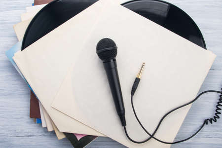 on the white background of the envelope, from a vinyl record, there is a black wired microphoneの写真素材