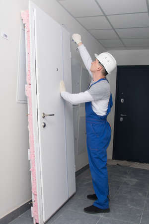 installation wizard, measures the height of the door with a tape measure, before replacing itの写真素材