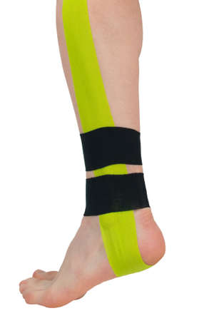 close-up of the leg, with three taped tips to support and relax the muscles when doing sportsの写真素材