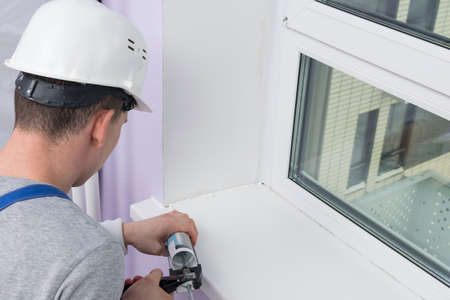 master window installer, seals the cracks with silicone from a professional gunの写真素材