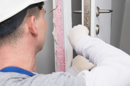 after installing the door, the master in a protective helmet, repairs the lock, close-upの写真素材