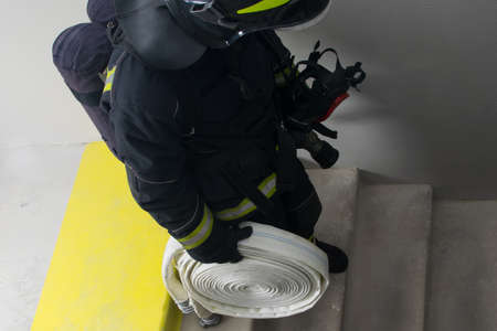 a firefighter goes down an unlit staircase with equipment, close-up of the stepsの写真素材
