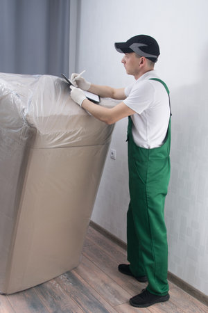 delivery courier, fills out documents for the guarantee of large-sized goods to the clientの写真素材