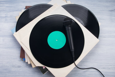 on a light gray desk, a stack of envelopes containing records with a microphone for recordingの写真素材