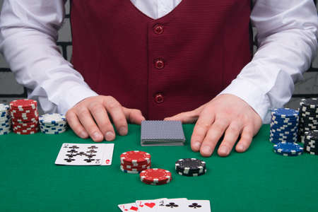on the green table, the moment of playing for money in the casino, a set of chips for bets and cardsの写真素材