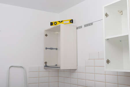 there is a level on the hanging kitchen cabinet to check the evenness of the kitchen furniture installationの写真素材