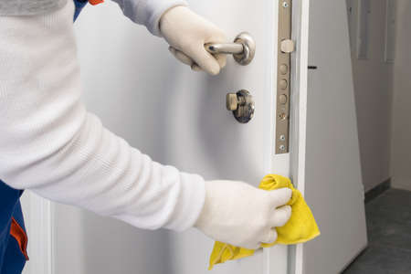 a worker cleans and washes the front door after it has been installedの写真素材