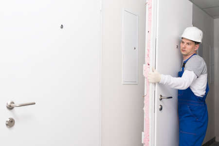 door installation worker replaced the old one with a new oneの写真素材