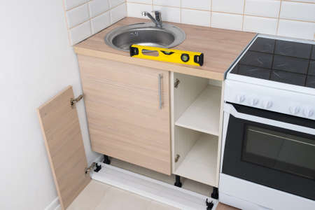 yellow level stands on the countertop of kitchen cabinetsの写真素材