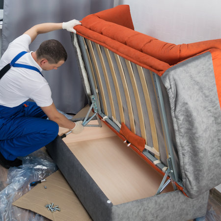 the upholstered furniture assembler adjusts the sofa mechanism, side viewの写真素材