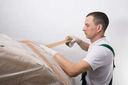 The delivery worker will pack the item into a large box before shipping itの写真素材