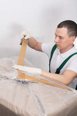 The delivery worker attaches a cover sheet with the order number before shipmentの写真素材