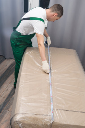 the deliveryman checks the dimensions of the delivered purchaseの写真素材
