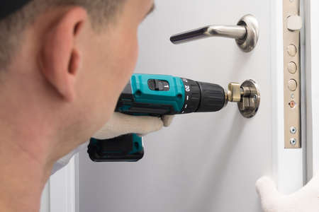 a worker repairs the closing mechanisms at the doorの写真素材