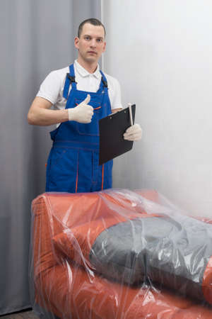 delivery worker shows with his hand the "class" delivery of goods to the buyerの写真素材