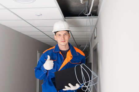 a worker has successfully completed setting up a secure internet in the building using a laptopの写真素材