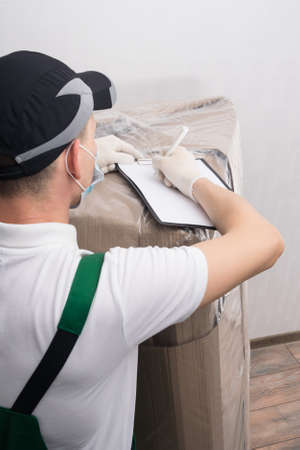 the courier fills out the documents for the delivered goods from the online storeの写真素材
