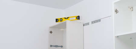 there is a level on the hanging kitchen cabinet to check the evenness of the installation of kitchen furniture, long photoの写真素材