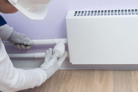 master of heating adjustment, sets the temperature on the sensor in the apartment, close-up, there is a place for the inscriptionの写真素材