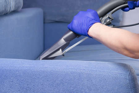 close-up of the washing vacuum cleaner, cleans the drapery of the sofa with waterの写真素材