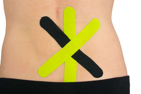 on the back of the back, tape  for relief of lower back pain, on a white backgroundの写真素材