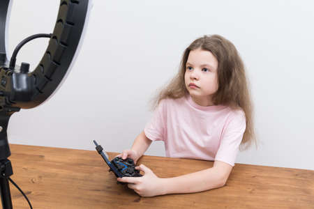 girl gamer, playing with a joystick in the game on the phone, with a circular lightの写真素材