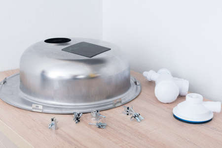 mounting clips for fixing a metal sink to a kitchen countertop and a sewer pipe, close-upの写真素材