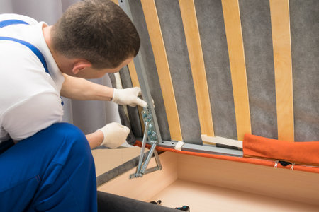 the deliveryman assembles upholstered furniture at the buyer's houseの写真素材