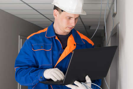 a worker configures the security of the network in the buildingの写真素材