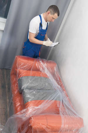 the courier fills out the documents after checking the delivered goods for defects and compliance with the ordered colorの写真素材