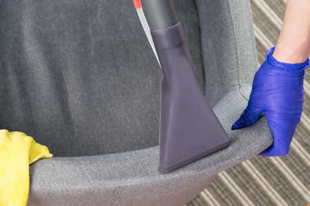 disinfection of the back of an office chair by an employee of a cleaning companyの写真素材