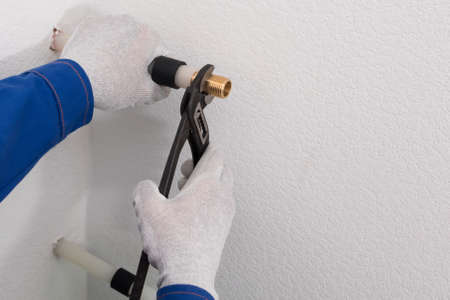 the plumber's hands run hot and cold water into the roomの写真素材