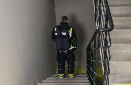 a firefighter goes down the stairs with a breathing apparatus
